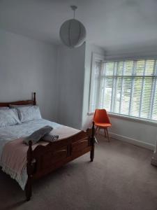 a bedroom with a bed and a chair and a window at Peaceful Bournemouth Family Retreat in Bournemouth