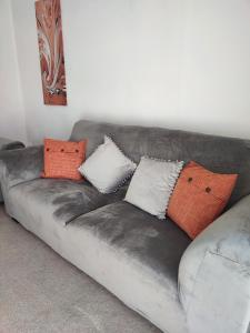 a grey leather couch with pillows on it at Peaceful Bournemouth Family Retreat in Bournemouth