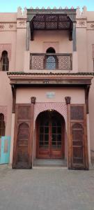 un edificio con due grandi porte in legno sopra di Marrakech Palmeraie village a Marrakech