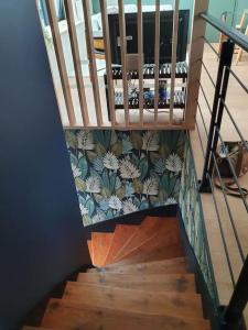 a wooden stair case with a floral wallpaper on the wall at Sous les toits de Saint-Félix in Nantes