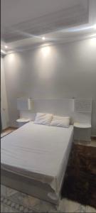 een slaapkamer met een wit bed met 2 kussens bij Marrakech Palmeraie village in Marrakesh