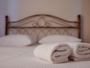 a pile of towels sitting on a bed at Vironas Hotel in Himare