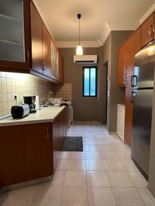 a kitchen with wooden cabinets and a stainless steel refrigerator at Spenny Sunrise Apartment in Xiropigado