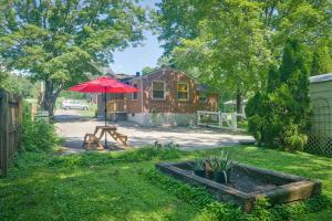 um quintal com uma mesa e um guarda-chuva vermelho em Cozy Nashville Getaway Near Lake Radnor and Downtown em Nashville