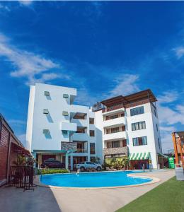 un gran edificio blanco con una piscina frente a él en Hotel Campestre Casa Laredo, en Chao