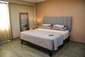 a bedroom with a large bed and a mirror at Hotel Campestre Casa Laredo in Chao
