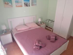 a bedroom with a pink bed with pink towels on it at ASTERIDE in Afitos
