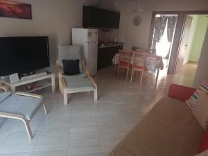 a living room with a couch and a tv and a kitchen at ASTERIDE in Afitos