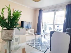 a living room with a plant in a vase at Wimbledon Apartment in London