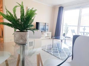 een woonkamer met een potplant op een paal bij Wimbledon Apartment in Londen