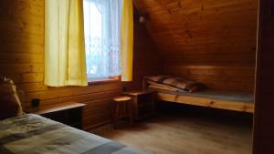a room with a bed and a window in a cabin at Domki Żaklin in Berezka