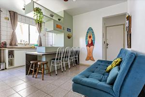 a living room with a blue couch and a kitchen at Apto a 30 metros do mar em Canasvieiras CBE105 in Florianópolis