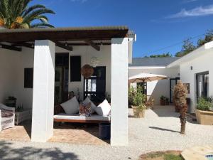 a patio of a house with a couch and an umbrella at Acacia Home in Graaff-Reinet