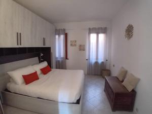 een slaapkamer met een wit bed met rode kussens en een stoel bij CORTE Apartment in Murano