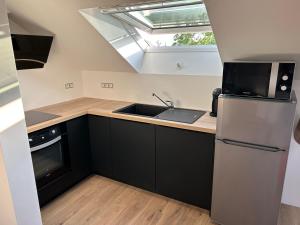 a kitchen with a sink and a refrigerator at La casa de Mimi in Sarralbe +5 photos