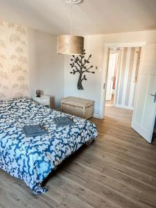 a bedroom with a bed and a tree on the wall at La casa de Mimi in Sarralbe