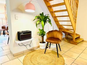 een stoel in een woonkamer met een trap bij La maison du Groove in Trois-Ponts