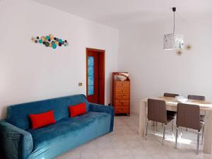 a living room with a blue couch and a table at CORTE Apartment in Murano