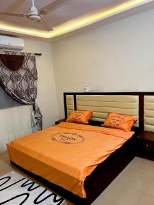 a bedroom with a bed with orange sheets and orange pillows at S2A apparts in Lomé