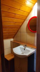 a bathroom with a sink and a red mirror at Domki Żaklin in Berezka