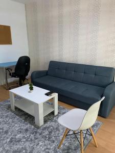 a living room with a blue couch and a table at Lungro's Square Apartment in Skopje