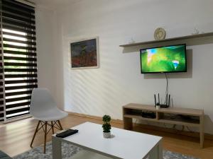 a living room with a television on a wall at Lungro's Square Apartment in Skopje