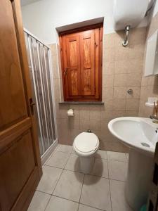 a bathroom with a toilet and a sink at B&B alle Roverelle in Viggianello