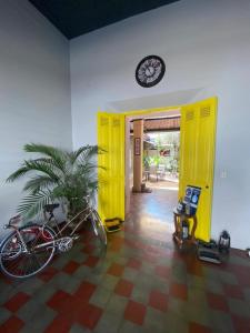 un vélo garé dans une pièce avec une porte jaune dans l'établissement Velvet hotel centro histórico, à Santa Ana
