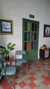 サンタ・アナにあるVelvet hotel centro históricoの椅子2脚とカラーガラスのキャビネットが備わる客室です。