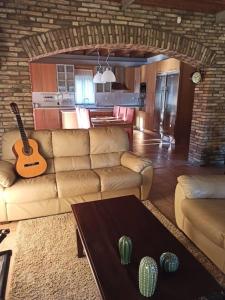 uma sala de estar com um sofá e uma guitarra em Σύγχρονη αγροικία em Lepanto