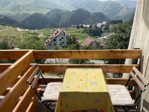 un tavolo e sedie su un balcone con vista sulle montagne di Monolocale Bellavista a Prato Nevoso