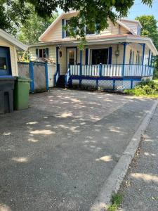 una casa con una valla azul delante de ella en Petite maison 2 bedrooms, en Lévis