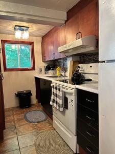 a kitchen with a white stove top oven next to a window at Petite maison 2 bedrooms in Lévis