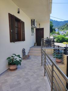 a balcony with stairs and potted plants on a house at Grand View Apartment in Panagia