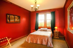 a bedroom with red walls and a bed and a window at The Ghost Lodge in Granity