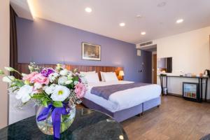 a hotel room with a bed and a table with flowers at La Wisteria Boutique Hotel Istanbul in Istanbul