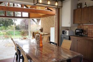 a kitchen with a wooden table with chairs and a kitchen with a tableablish at L'Escapade du Vexin normand - Spa in Longchamps