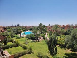 un complexe avec une piscine et des palmiers dans l'établissement La Perle de Marrakech by Atlas Golf Resort, à Marrakech