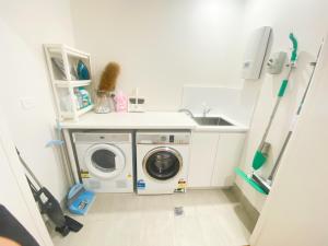 a laundry room with a washing machine and a sink at Sweet home 2BR/2BA/2CAR Denman in Weston Creek