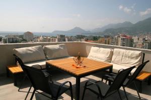 a table and chairs on a balcony with a couch at The Olive Trees Penthouse - two bedroom in Bar