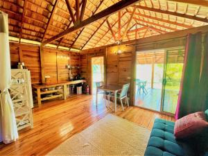 a room with a table and chairs in a cabin at RAIATEA - Orion Pool Bungalow in Uturoa