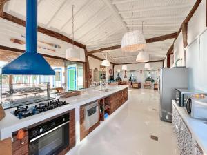 a large kitchen with white counter tops and appliances at Blow Show Casa III Guest House in Ilhabela