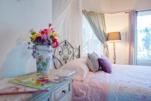 ein Schlafzimmer mit einem Bett mit einer Vase aus Blumen auf dem Tisch in der Unterkunft IreneHouse Victorian INN in Sacramento