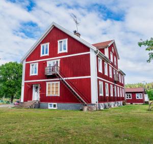 a large red barn with a white trim at Hässlebogården Turist & Konferens in Mariannelund