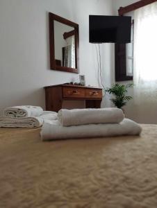 Pokój z telewizorem i komodą z ręcznikami na podłodze w obiekcie Patmos house Leo & Mary w mieście Patmos