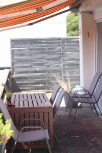 d'une terrasse avec des chaises, une table et une clôture. dans l'établissement SPA-Apartment mit Sauna in Ulm-Böfingen, à Ulm