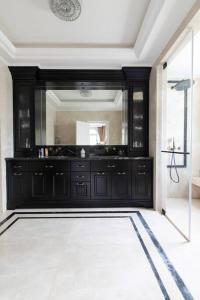 a bathroom with a black vanity and a mirror at Luxurious & Exclusive Villa, 10 min from the beach in Herzelia 