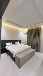Un dormitorio con una cama grande y una ventana en شقق ميسم الورد للشقق المفروشه en Mahlal