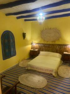 1 dormitorio con 2 camas y lámpara de araña en Dar Garindi, en Asilah
