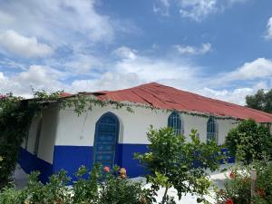 un edificio blanco y azul con techo rojo en Dar Garindi, en Asilah
